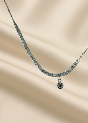 Silver necklace with a row of zircons and a hanging detail