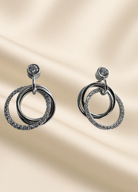 Silver dangling earrings with intertwined circles and zircons